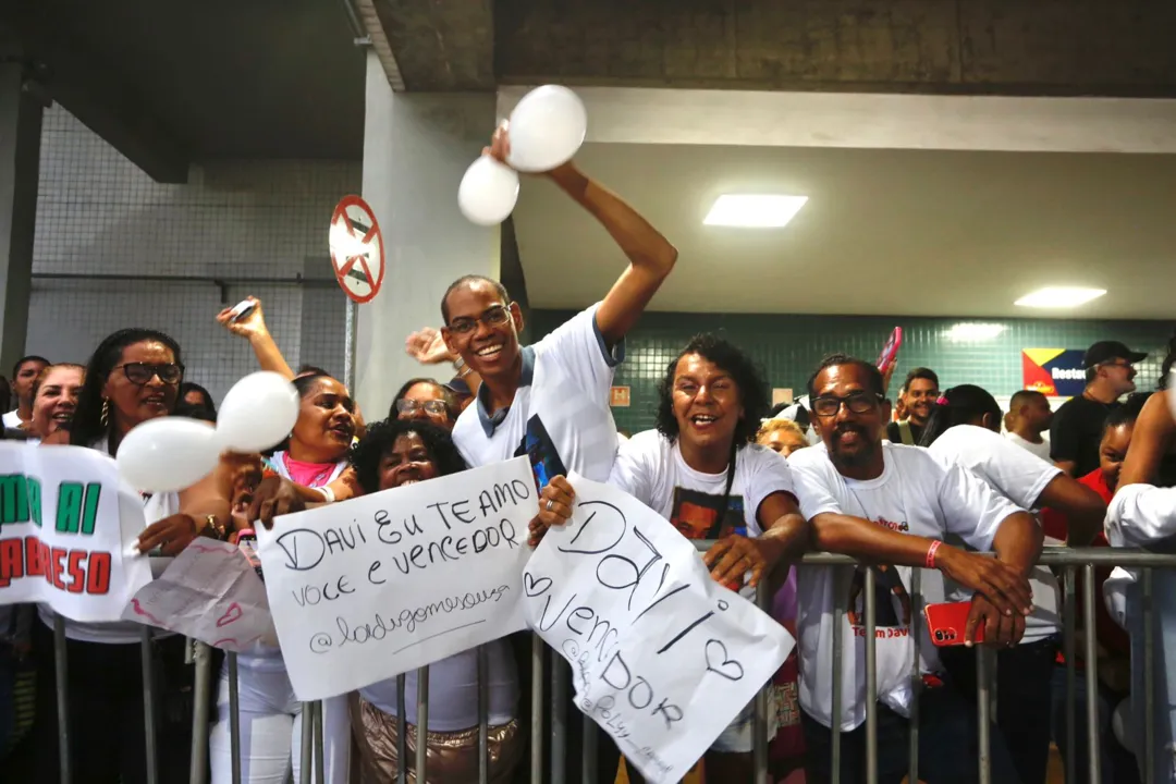 Fãs de Davi com cartazes e camisas personalizadas no aeroporto