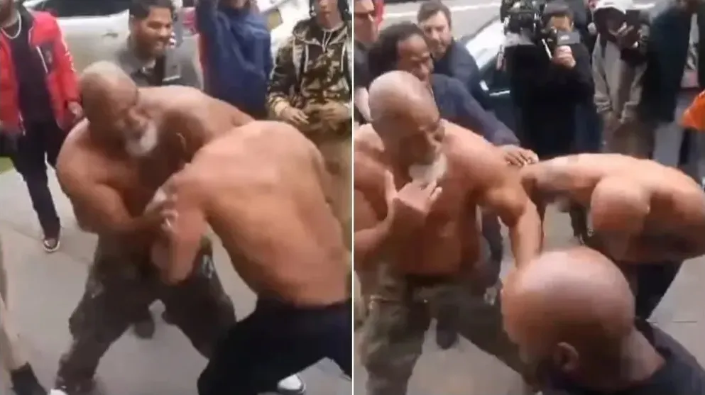 Mike Tyson e Shannon Briggs estão sem camisa e são acompanhados por uma roda de pessoas