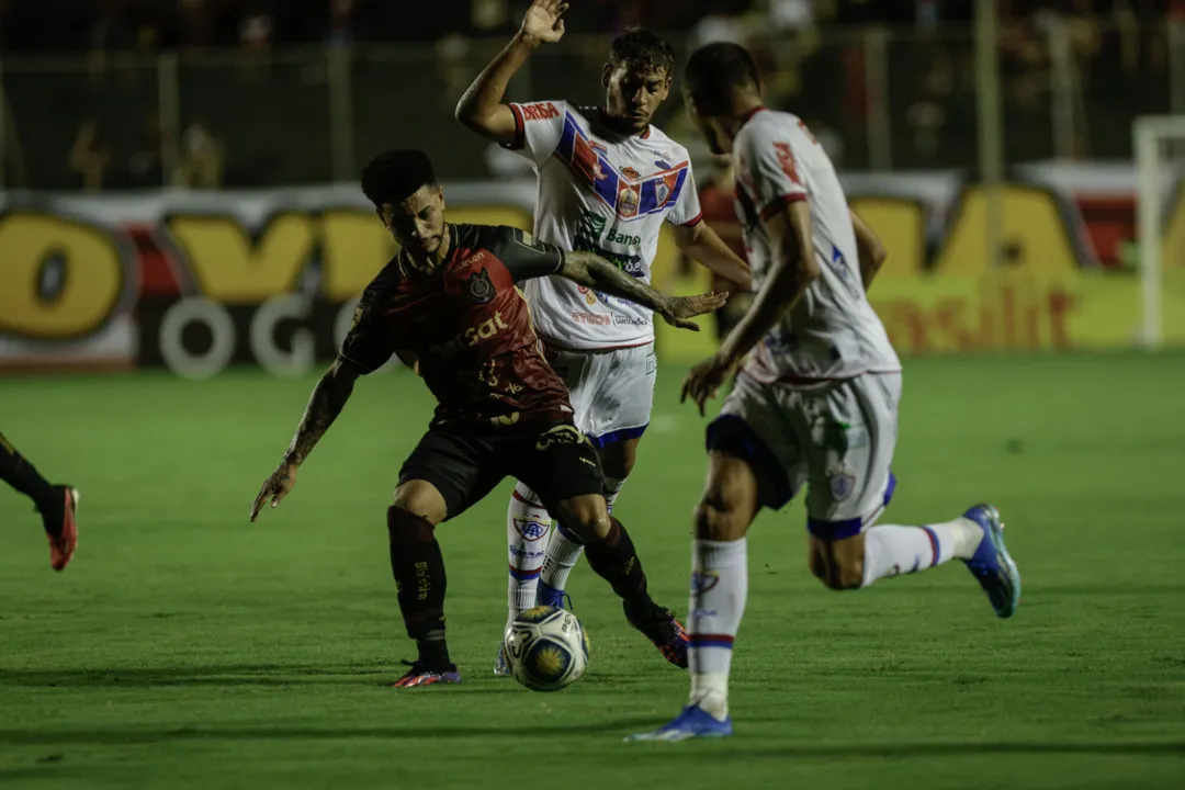 Matheusinho em disputa de bola com adversários