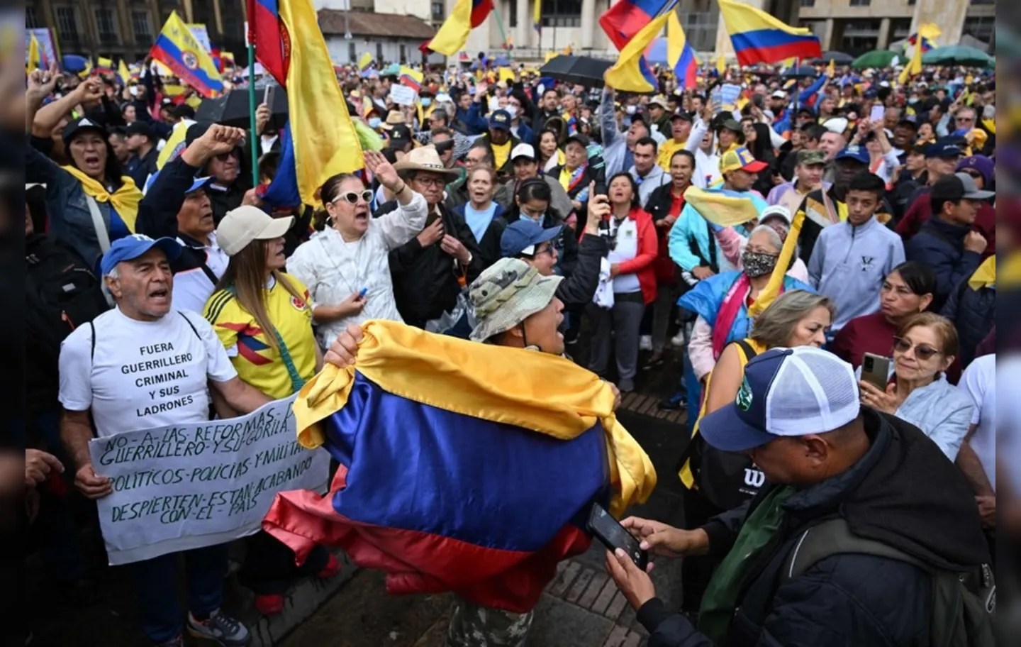Pessoas seguram bandeiras da Colômbia durante uma manifestação contra o governo
