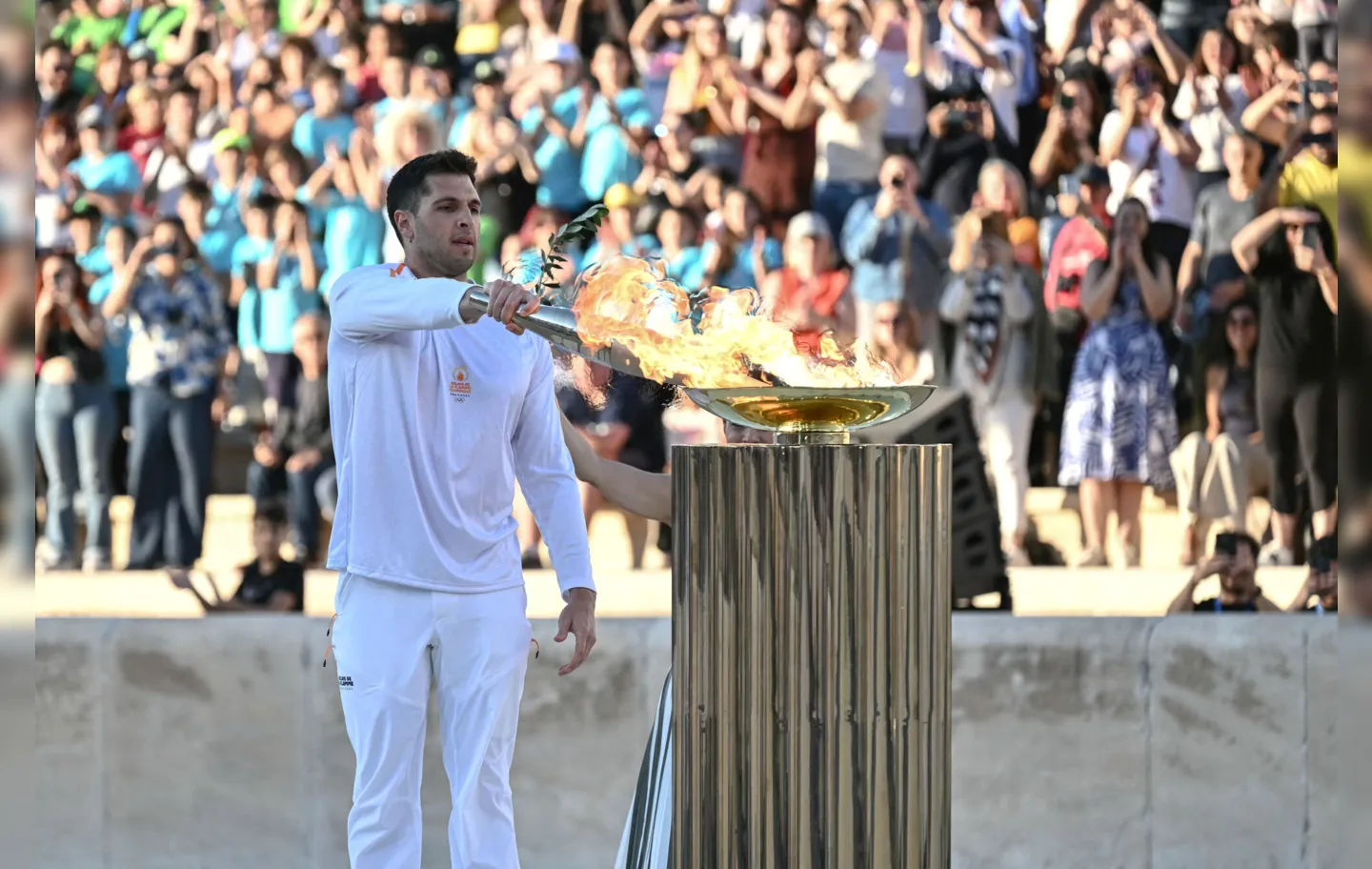 Capitão da equipe de pólo aquático da Grécia, Ioannis Fountoulis, acende a pira olímpica