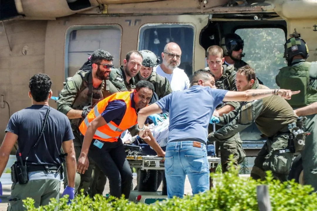 Uma pessoa ferida é transferida de um helicóptero da Força Aérea Israelense pousando nas dependências do Centro Médico Sheba Tel-HaShomer em Ramat