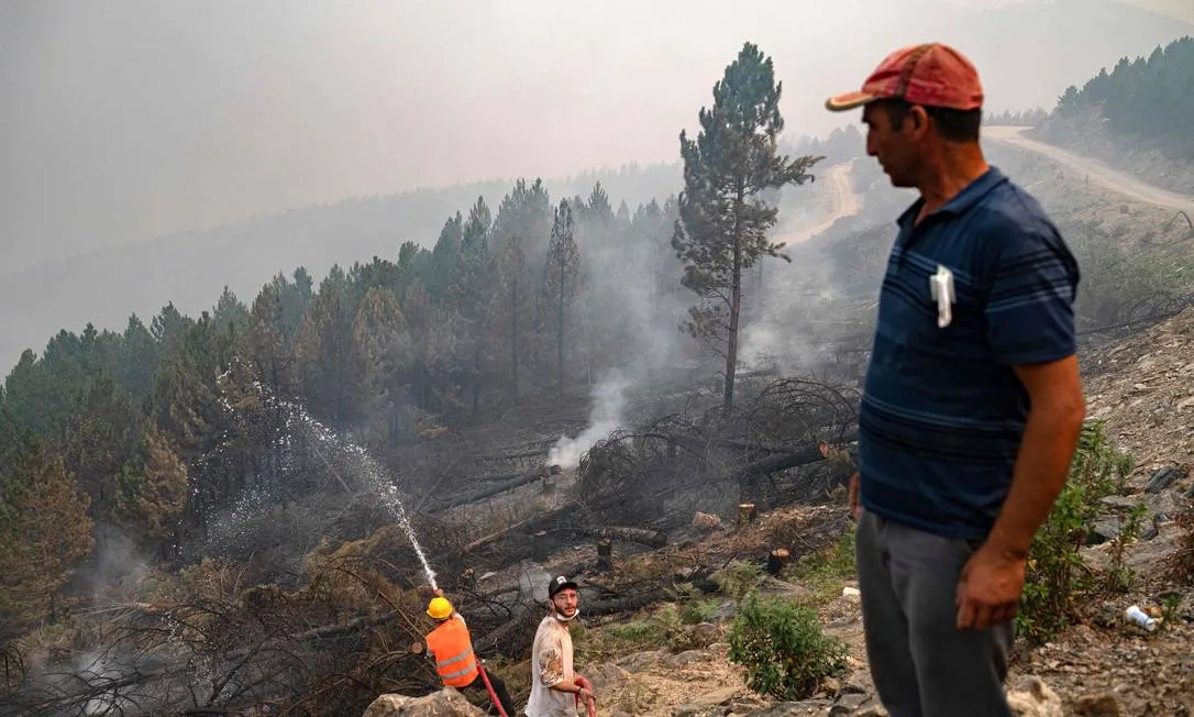 Voluntários jogando água nos focos de incêndio florestal em 2021