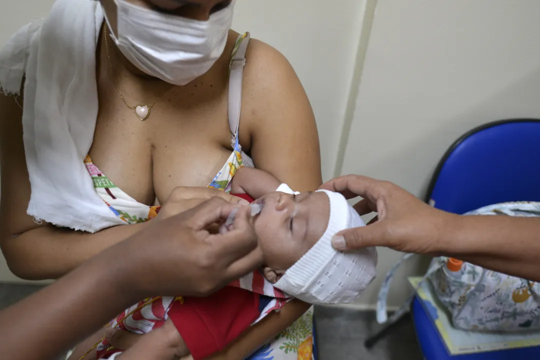 Bebê sendo vacinado no 5º Centro de Saúde Clementino Fraga com dose de multivacina e poliomielite: Bahia registra alta de imunizações