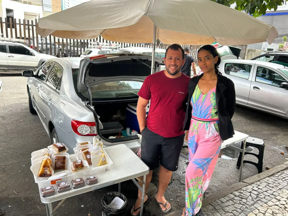 Tiago Almeida vende bolos e salgados ao lado na companheira na avenida Tancredo Neves