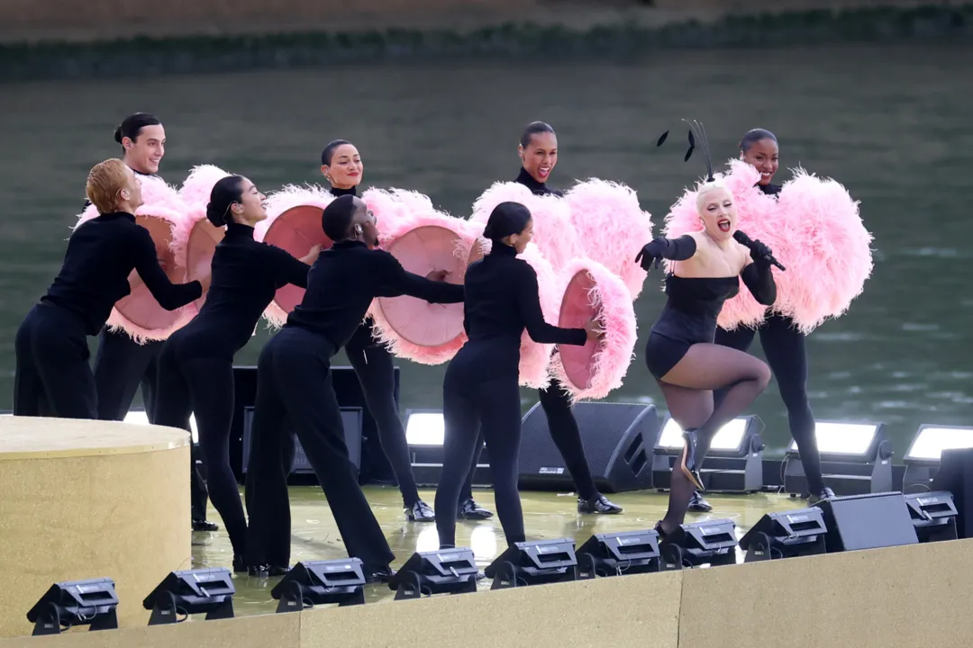 Vestida com uma plumagem rosa, a artista cantou o clássico francês Mon Truc en Plumes