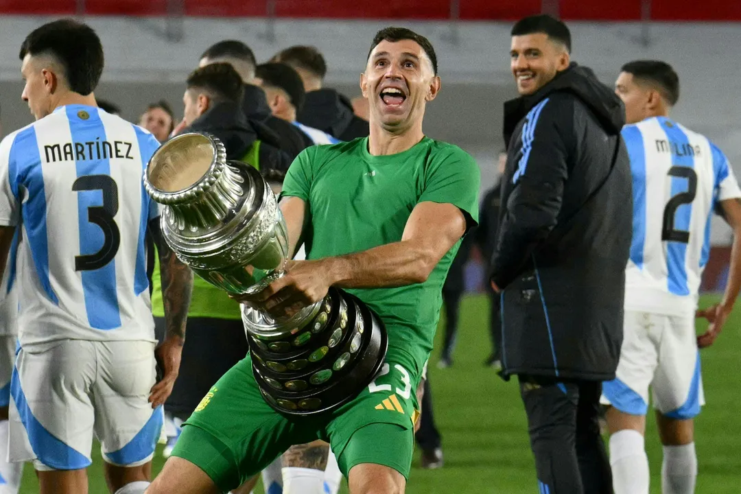 (ARQUIVOS) O goleiro argentino Emiliano Martinez gesticula enquanto comemora com uma réplica do troféu da Copa América