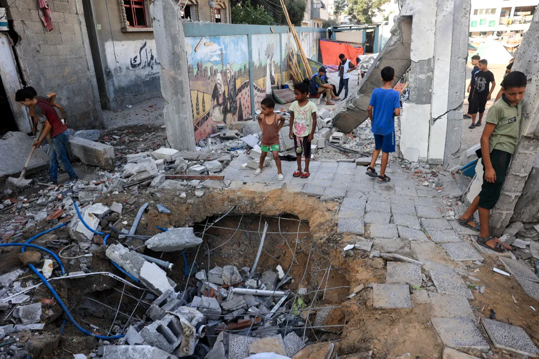 Children check the destruction at a UN-run school after Israeli bombardment in Nuseirat in the central Gaza Strip on July 9, 2024, amid the ongoing conflict between Israel and the Palestinian Hamas militant group. The Israeli military said its air force had struck "several terrorists" who were using a Nuseirat school "as cover". A source at the local Al-Awda hospital said it had received several wounded after an attack on a school run by the UN agency UNRWA. (Photo by Eyad BABA / AFP)