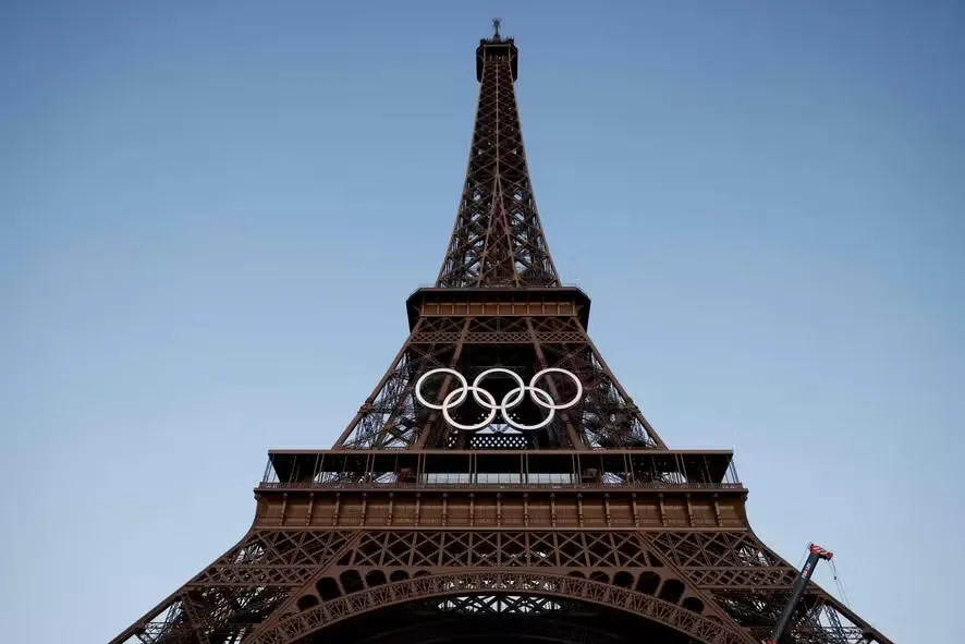 Os anéis olímpicos na Torre Eiffel, cartão-postal de Paris