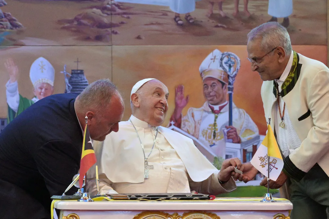 O Papa Francisco interage com o Presidente do Timor Leste, José Ramos-Horta (D), após assinar um livro de visitas durante o encontro no Palácio Presidencial em Dili