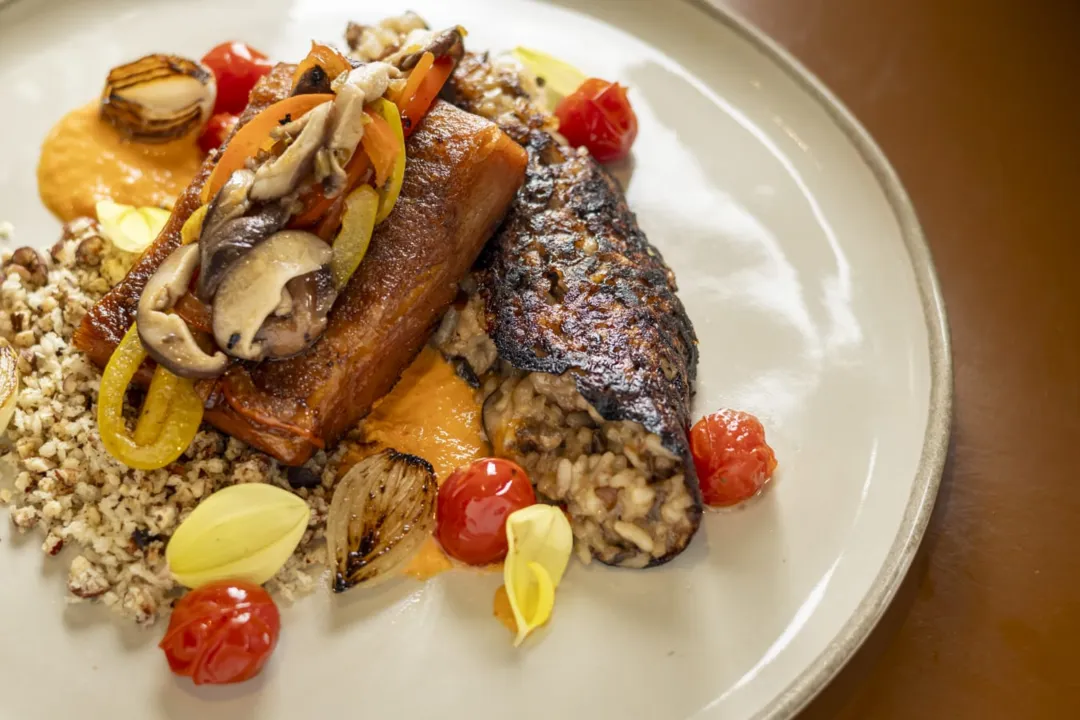 Bacalhau do Sertão - Bacalhau de pirarucu confitado com socarrat de cogumelos, molho de pimentão vermelho e limão siciliano, e farofa de licuri com maracujá do cerrado