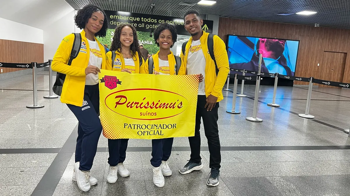 Atletas posam ao lado do treinador momentos antes do embarque, em Salvador