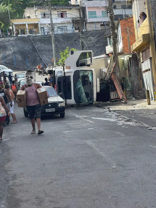 Imagem ilustrativa da imagem Caminhão tomba, esmaga carro e carga de carne é saqueada em Salvador