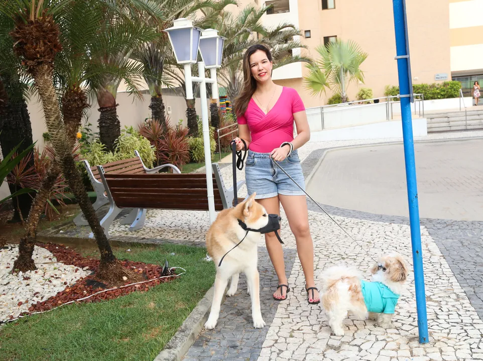 Seguindo as normas de segurança, Márcia utiliza focinheira e guia na hora de passear com os dois cachorros