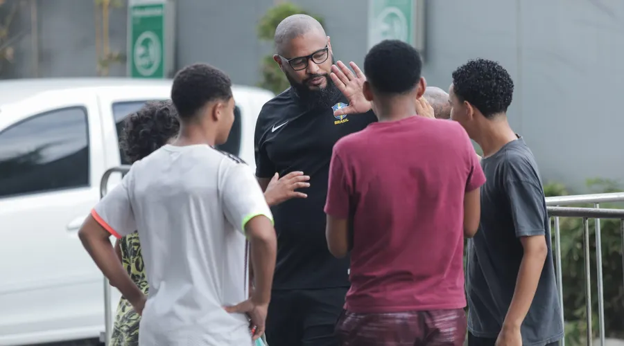 Garotos conversam e tiram fotos com um dos seguranças da seleção, Edson Emiliano