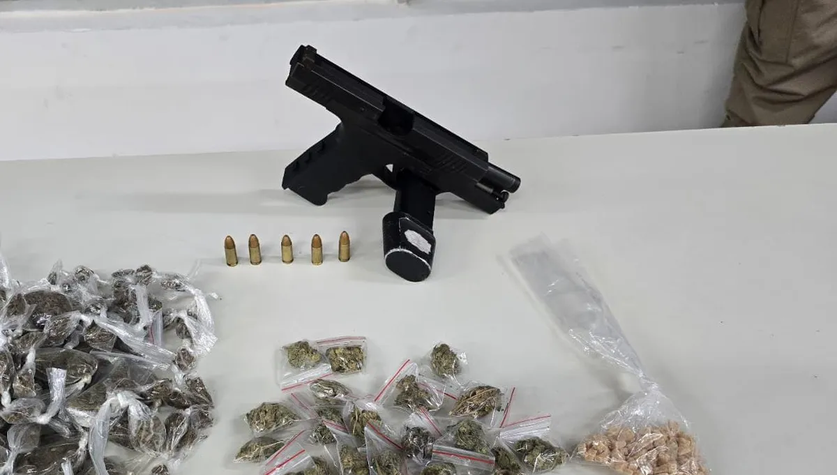 Uma pistola calibre 9mm, carregador, munições e porções de drogas foram apreendidos.