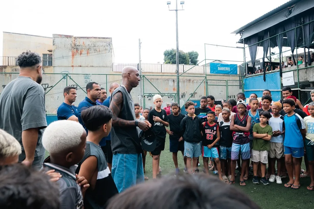 Anderson Talisca com crianças durante ação no bairro Aviário