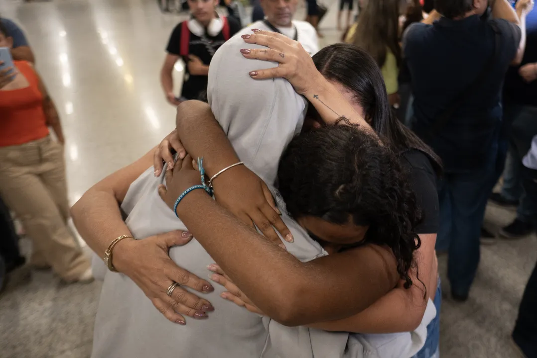 Um homem deportado dos EUA é recebido por parentes no Aeroporto Internacional de Confins, em Confins, estado de Minas Gerais