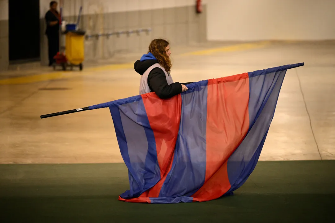 A staff member takes away the FC Barcelona's flag following the decision to cancel the Spanish league football match between FC Barcelona and CA Osasuna at Estadi Olimpic Lluis Companys in Barcelona on March 8, 2025. The match was cancelled due to the decease of the FC Barcelona's team doctor Carlos Minarro Garcia. (Photo by Josep LAGO / AFP)