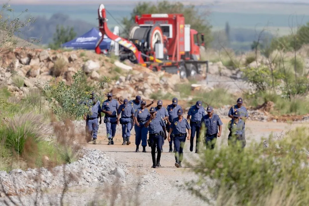 Oficiais do Serviço Policial Sul-Africano perto de um Metalliferous Mobile Rescue Winder durante uma operação de resgate