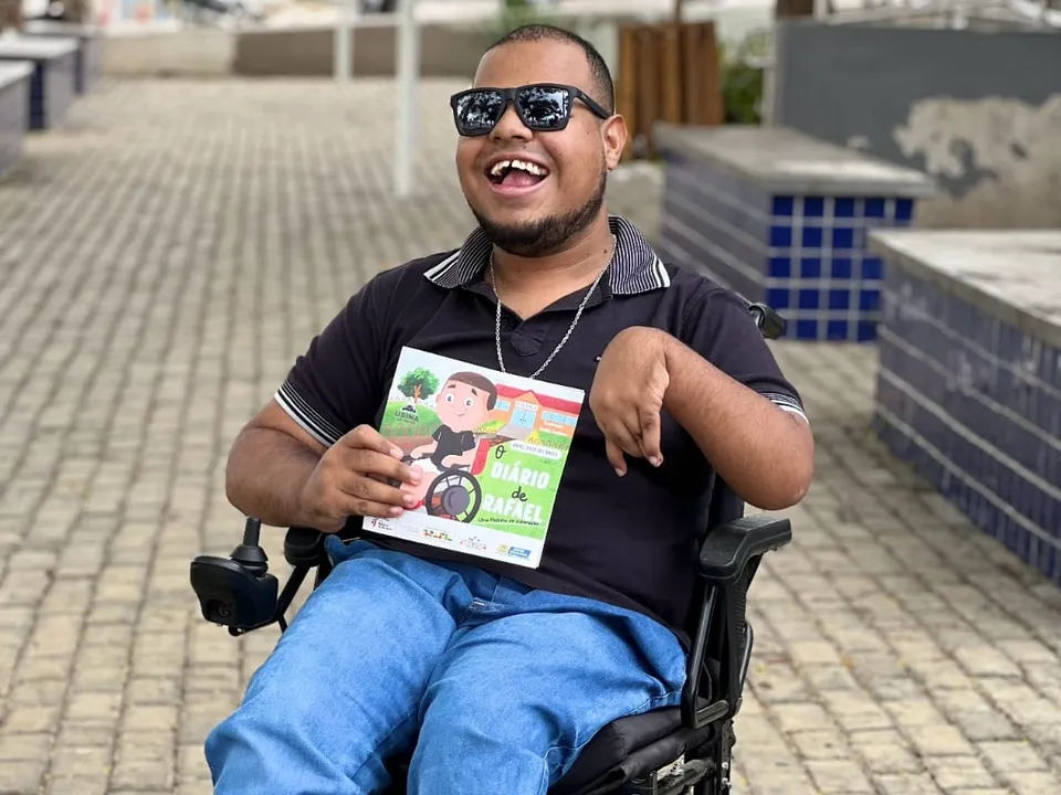 Rafael posa com o livro