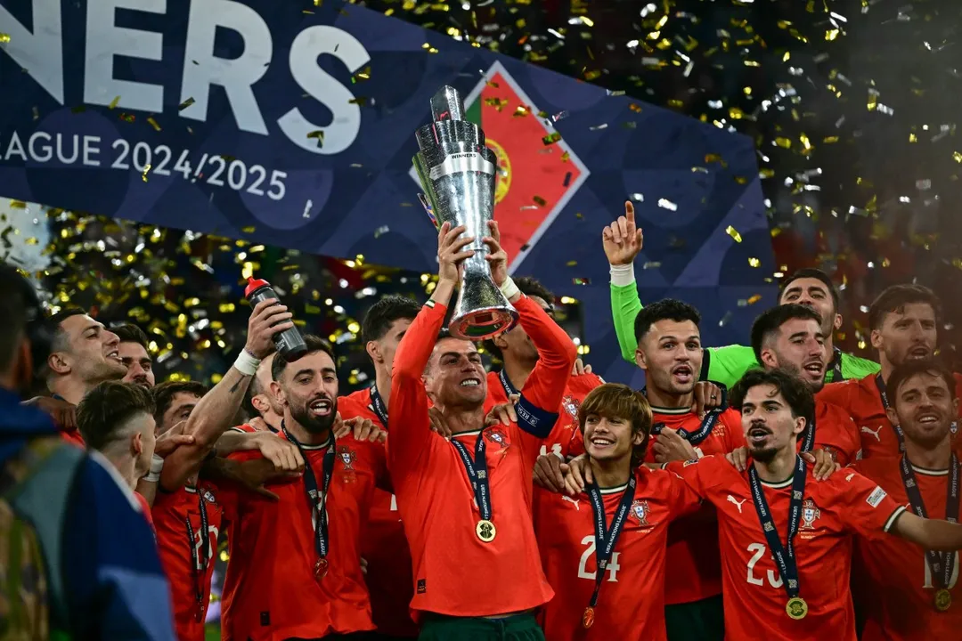 Portugal's players including Portugal's forward #07 Cristiano Ronaldo celebrate with the trophy after winning the UEFA Nations League final football match between Portugal and Spain in Munich, southern Germany on June 8, 2025. (Photo by Tobias SCHWARZ / AFP)