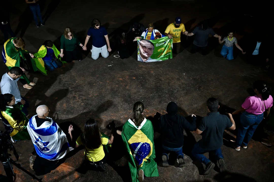 Apoiadores de bolsonaro oram em frente à casa do ex-presidente