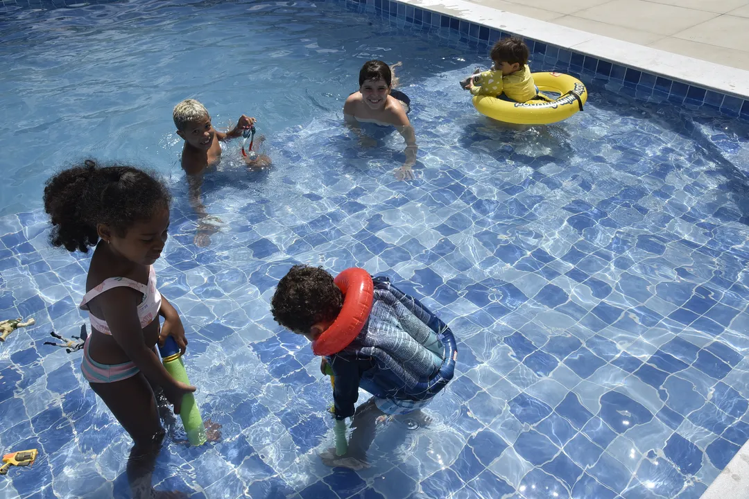 Crianças brincam em piscina sem equipanentos pessoais ou supervisão de adulto