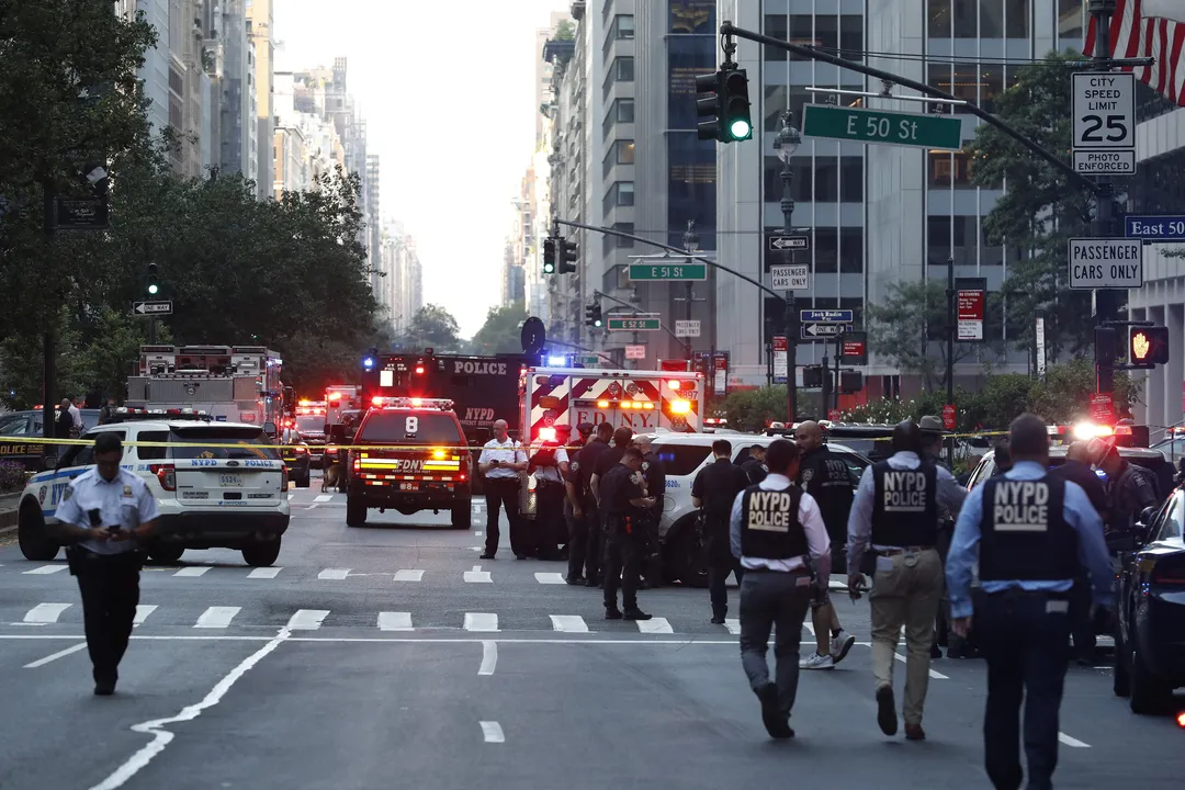 Police officers and emergency vehicles are seen in a street as police respond to a shooting incident in the Midtown Manhattan neighborhood of New York on July 28, 2025. Police swarmed Midtown Manhattan on Monday as the mayor of New York City said there was "an active shooter investigation" amid reports a police officer had been struck. New York City police commissioner Jessica Tisch said that the gunman, who had been on the loose in the busy Midtown district of Manhattan, had been "neutralized." (Photo by John Lamparski / AFP)