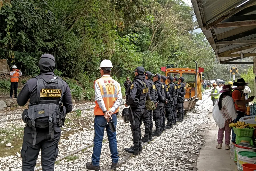 Policiais de guarda posam para uma foto nos trilhos do trem perto de Machu Picchu Pueblo