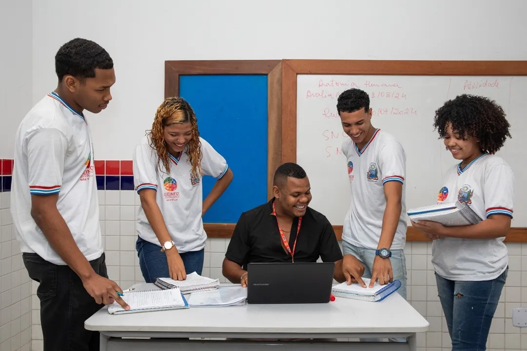 Professor em sala de aula ao lado dos alunos