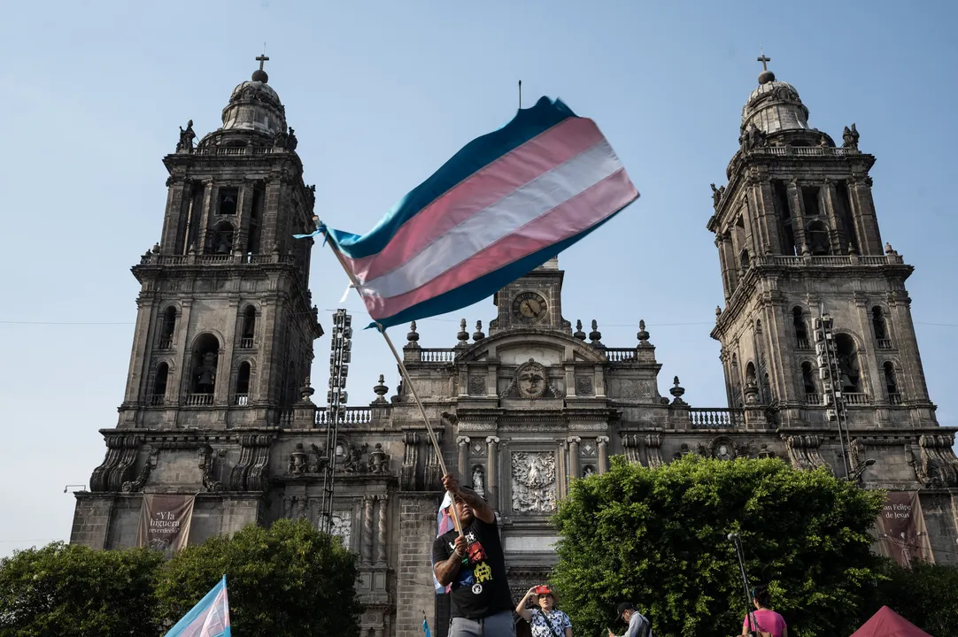 Manifestante agita uma bandeira transgênero durante um protesto.