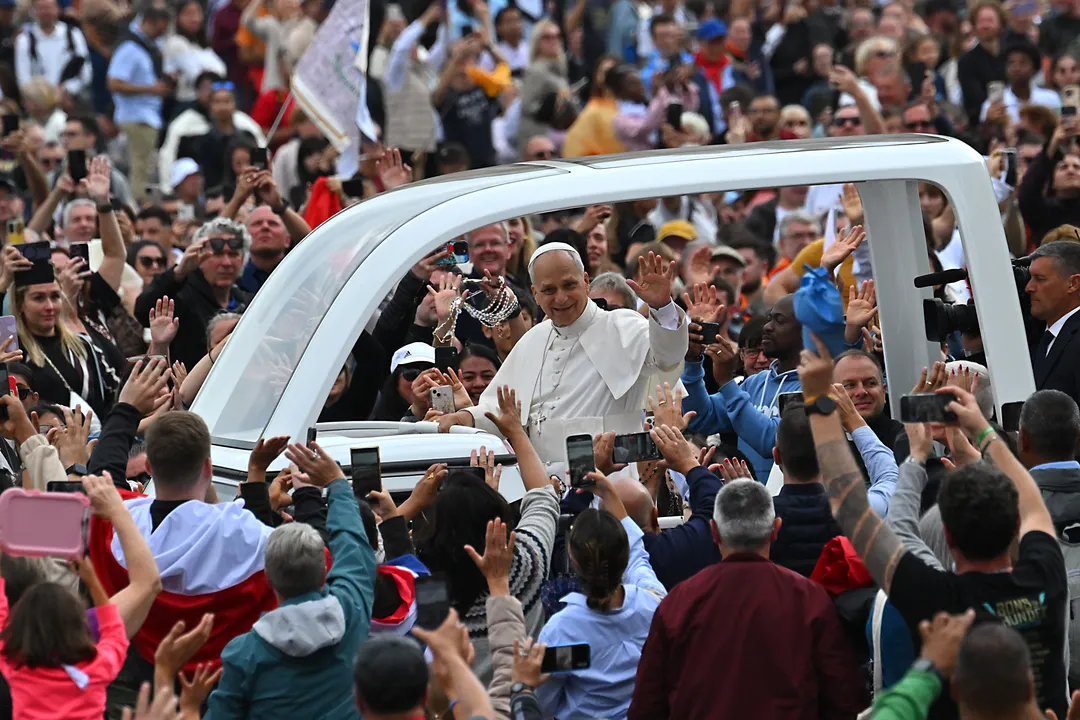 Papa Leão XIV (C) acena para os fiéis do papamóvel ao deixar a Praça de São Pedro