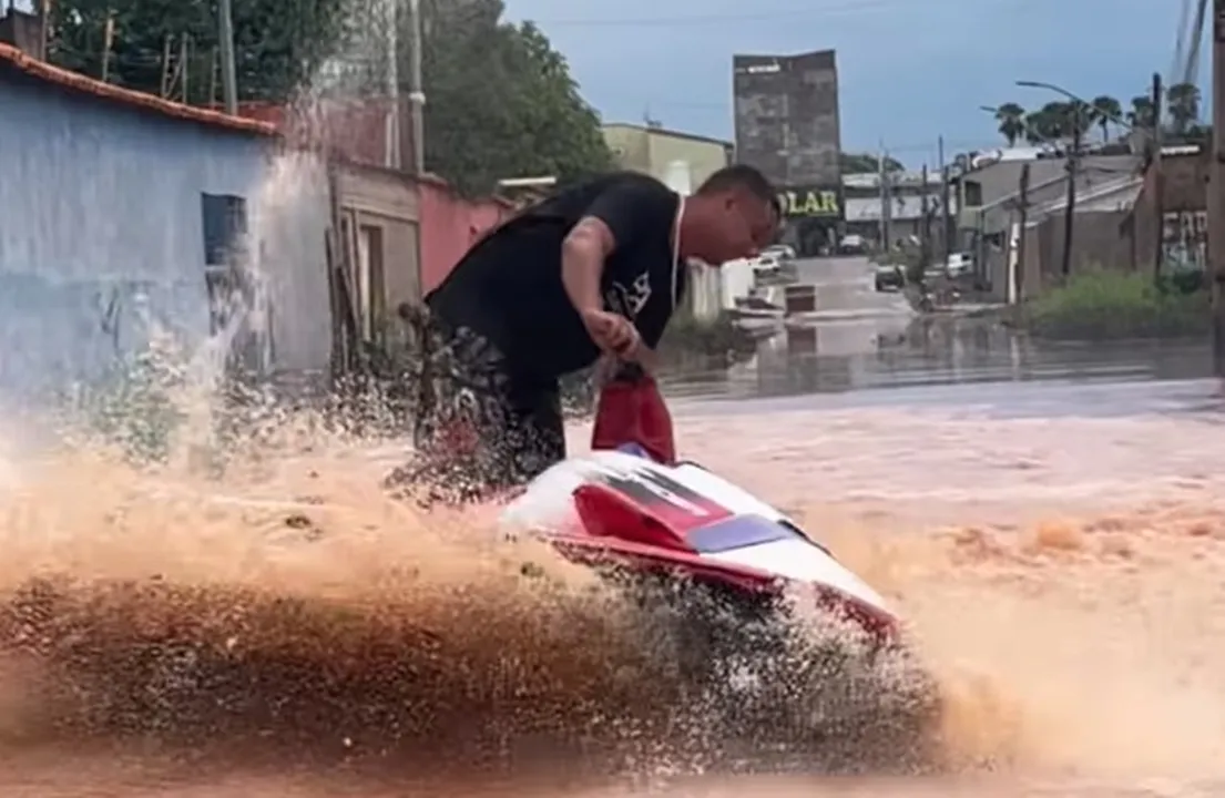 Homem anda de jet ski em rua alagada na cidade de Planaltina (GO)