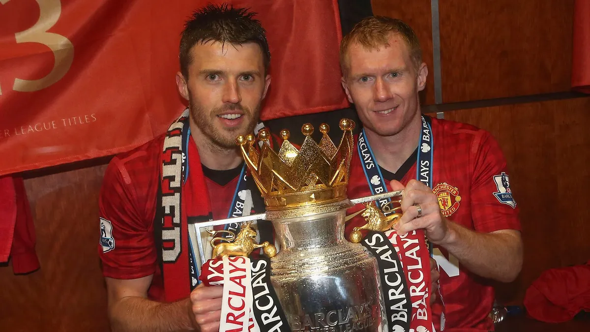 Michael Carrick, novo treinador do Manchester United, segura a taça do Campeonato Inglês ao lado de Paul Scholes