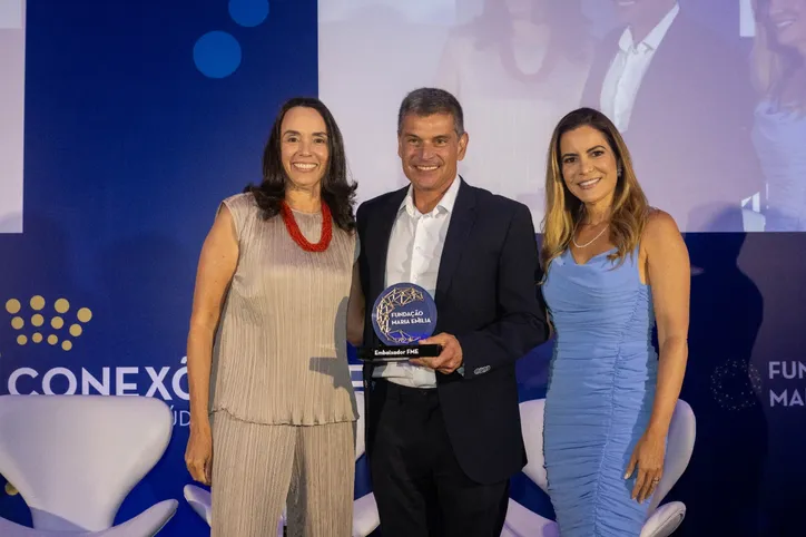 A diretora–presidente, Thereza Tourinho, e a diretora–executiva, Thamile Accioly, com o homenageado Luís Cláudio Correia