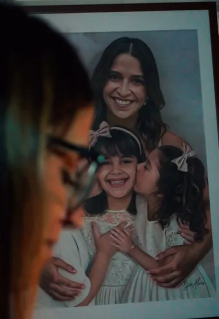 Ana Carolina Oliveira de frente a um quadro com os três filhos, incluindo Isabella Nardoni