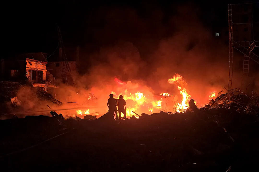 Forças de defesa civil tentam extinguir um incêndio após bombardeio israelense