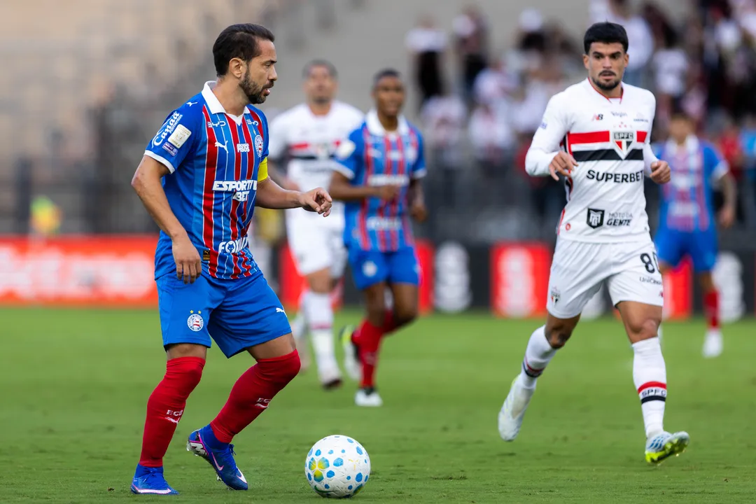 Everton Ribeiro na partida contra o São Paulo. Cauly aparece ao fundo da imagem