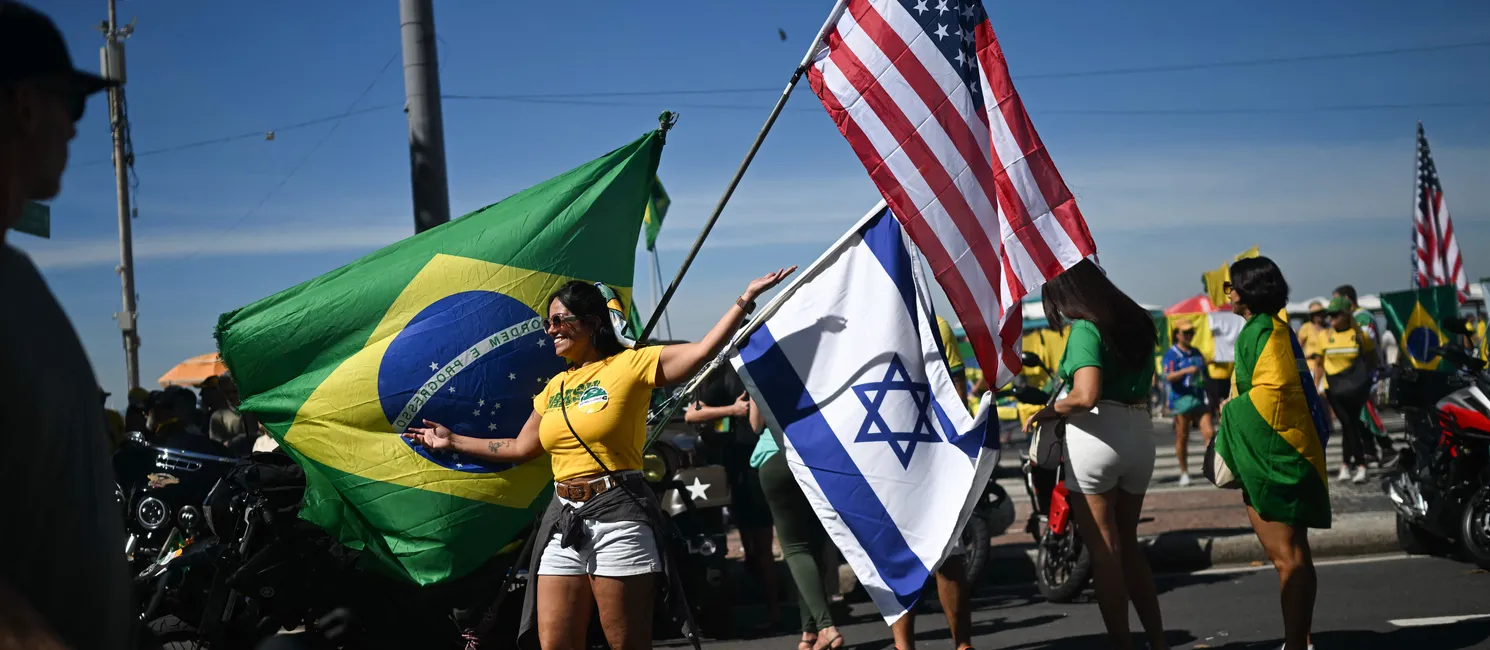 Grupo agita bandeiras do Brasil, de Israel e dos Estados Unidos na praia de Copacabana
