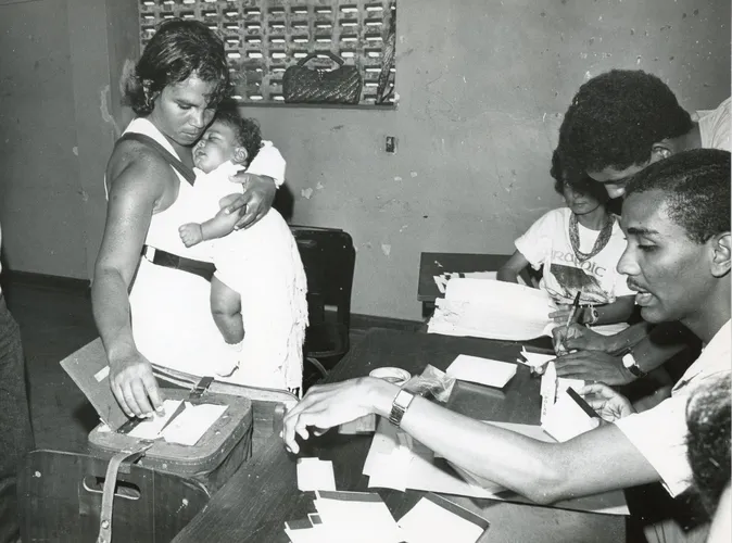 Eleitora vota no Colégio Luiz Viana com um bebê de colo