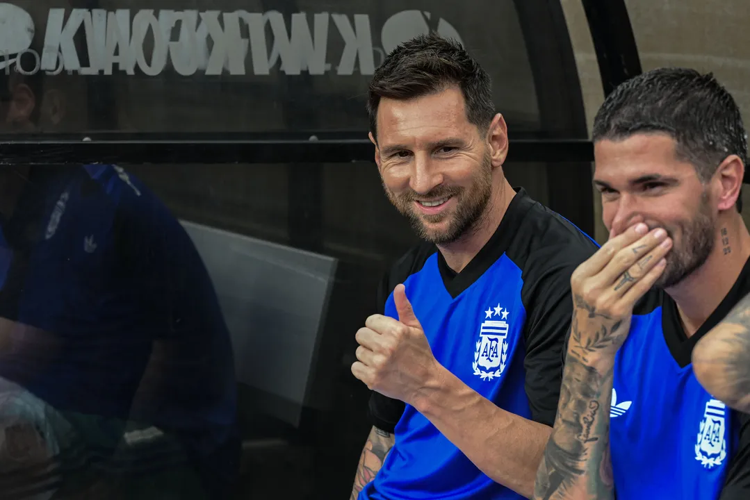 Messi e Rodrigo De Paul resenham no banco do College Station, Texas, em amistoso