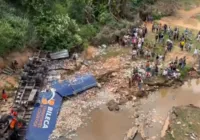 Motorista fica preso a ferragens após caminhão cair de ponte