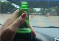 Motorista é multada após postar foto com garrafa de cerveja
