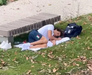 Atleta dorme no gramado para fugir do calor em quarto da Vila Olímpica