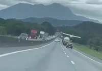 Avião faz pouso forçado em acostamento entre carros e caminhões; vídeo imagem