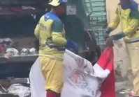Garis são flagrados utilizando bandeira do Vitória para catar lixo imagem