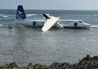 Avião em pane sai da pista e para a metros do mar imagem