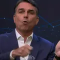 Flávio Bolsonaro faz cola na mão e provoca Lula no debate da Band imagem