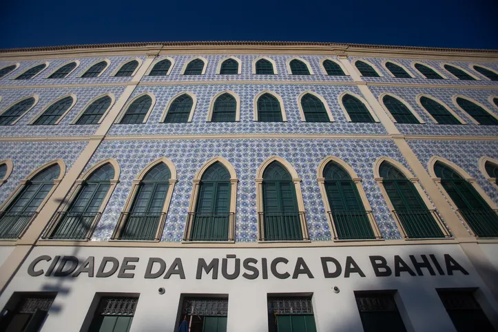 Localizada no bairro do Comércio, próxima ao Mercado Modelo, a Cidade da Música é um verdadeiro polo cultural dedicado à sonoridade de Salvador. O espaço conta com mais de 700 horas de acervo, proporcionando uma imersão na história musical da cidade.
<br>
<br>
"Ele permite com que todas essas pessoas tenham acesso, tanto as que visitam aqui em momentos como esse, que é o de janeiro, na qual a gente tá ali, com espaço, muita visitação a partir de grupos de turistas, como também no decorrer do ano, com grupos escolares diferentes", Geancarlos Barbosa, supervisor geral do espaço.
<br>
<br>
Durante a visita, os turistas podem participar de apresentações percussivas, visitas guiadas e programações especiais nos fins de semana, levando uma experiência completa para todas as idades.